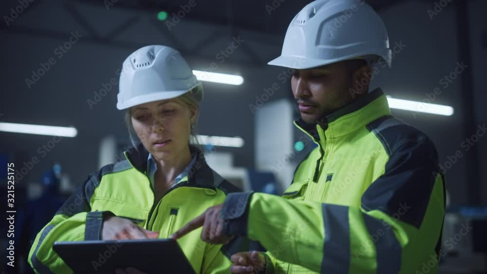 Aufkleber Chief Engineer and Project Manager Wearing Safety Vests and Hard Hats, Use Digital Tablet Computer in Modern Factory, Talking, Optimizing Production Line. Industrial Facility with CNC Machinery