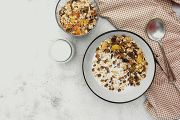 Bowl of oatmeal cereal. Whole oats, granola with dried fruit and blueberry, milk and honey. Healthy food breakfast. Copy space.