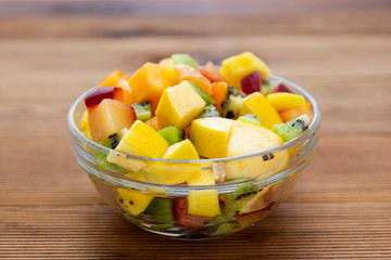 Fresh fruits salad glass bowl - mango, citrus, kiwi fruit, plum and persimmon. Healthy food. Smoothie mix.