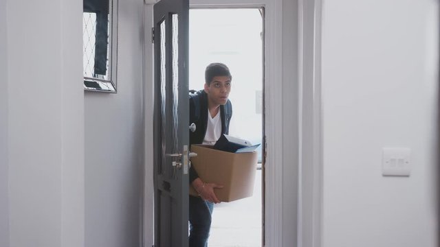 Male College Student Carrying Box Moving Into Accommodation