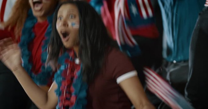 Excited Fans With US Flags Celebrating Victory. Group Of American Soccer Fans Celebrating Championship Win At Sports Stadium