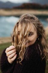 Naklejka premium Portrait of beautiful romantic woman standing near lake. She is smiling and enjoying her time. 