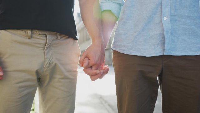 Close Up Of Loving Male Gay Couple Holding Hands Outside On Street