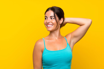 Young woman over isolated yellow background laughing