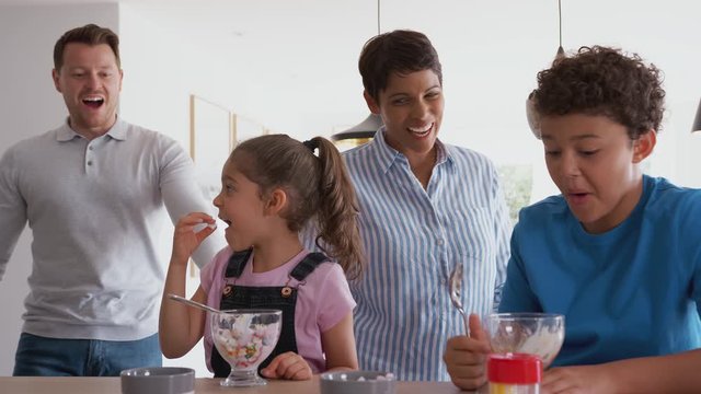 Parents Catch Children In Kitchen At Home Eating Ice Cream