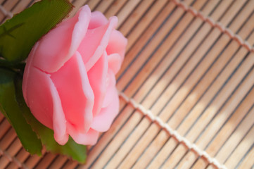 pink handmade soap in the shape of a rose on a window background	
