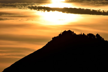 Mountain silhouette with house and trees on top on an amazing winter sunset in Granada