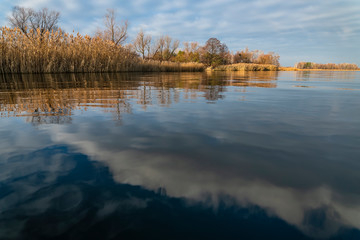Naklejka na ściany i meble Early spring or late autumn at lake. Fishing landscape background with copy space