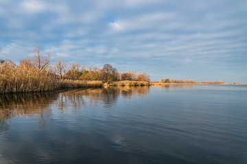 Fototapeta na wymiar Early spring or late autumn at lake. Fishing landscape background with copy space