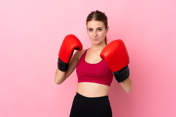 Young sport woman over isolated pink background with boxing gloves