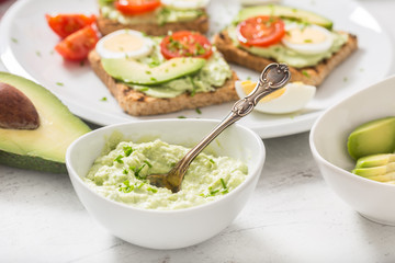 Avocado spread guacamole toasts egg tomato chives as breakfast meal or appetizer