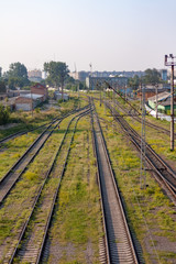 Fototapeta na wymiar Urban railroad landscape with rails following into the frame.