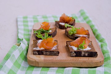 Appetizer, open sandwiches on rye bread with slightly salted salmon and butter. Swedish cuisine. Selective focus.