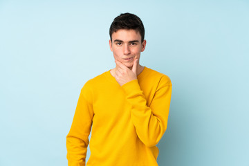 Teenager caucasian handsome man isolated on purple background thinking