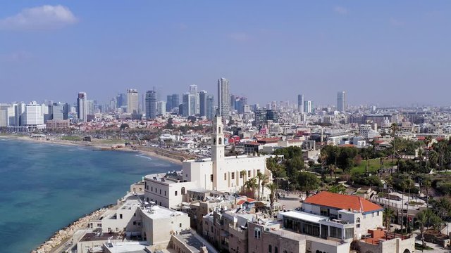 Tel Aviv and Jaffa skyline, aerial view above the old city and port of Jaffa with modern TLV coastline in the distance.