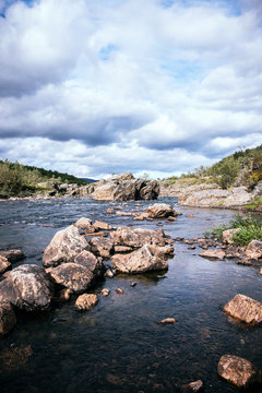 Landscape image of wide river with big rocks, Lakselv, Norway