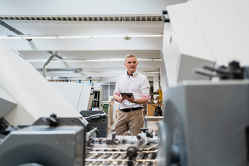 Businessman using a tablet in a factory