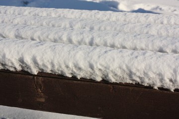 Wooden bench with snow in the Park 