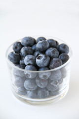Fresh blueberries in a small glass on a white background. Healthy eating. Vegan food. Back view.