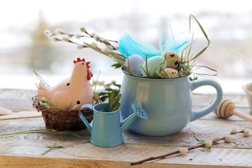 Easter decoration, toy chicken, eggs, pussy-willow twigs on a wooden windowsill, spring, festive home decor