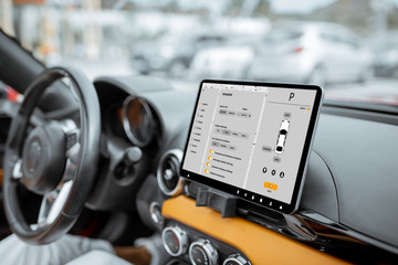 Car dashboard with a digital touchscreen with launched application for vehivle control, close-up...