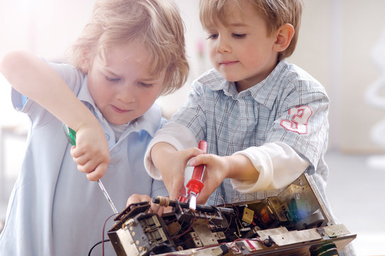 Two little boys disassembling an old radio