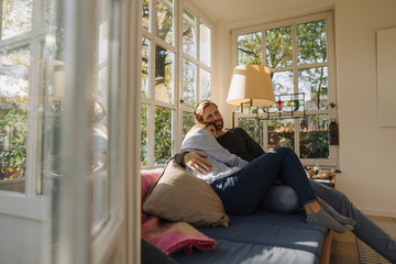 Affectionate couple relaxing in sunroom at home