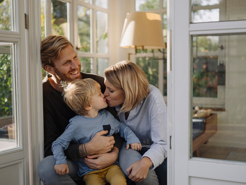 Happy and affectionate family in sunroom at home