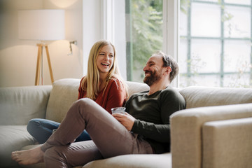 Couple sitting at home on couch, talking
