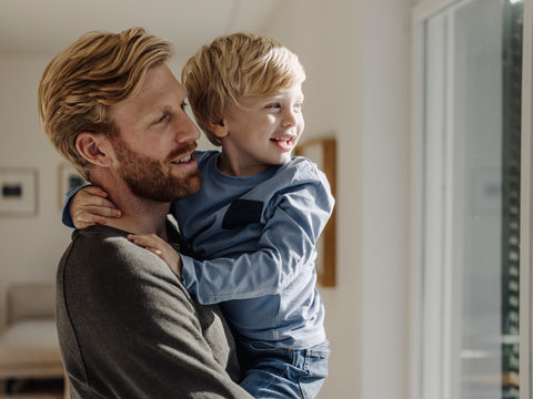 Happy father carrying son at home