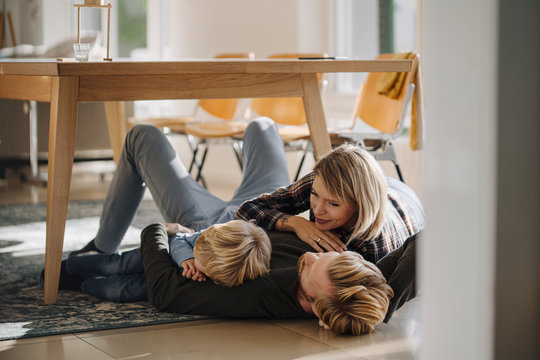 Happy Relaxed Family Lying On The Floor Together At Home