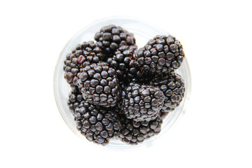 Fresh blackberries in a small glass on a white background. Healthy eating. Vegan food. Top view.