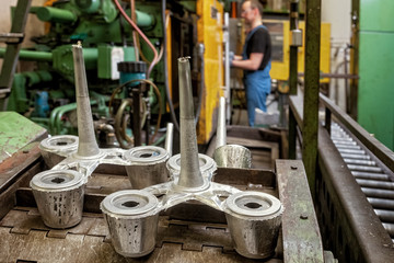 Pieces coming out of a die casting machine