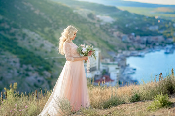 Pregnant woman in nature. Beautiful female future mother in white long dress outdoors