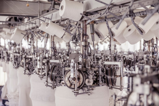 White cotton reels on a machine in a factory