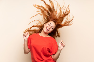 Teenager redhead girl dancing over isolated background