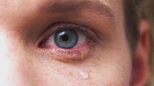 Extreme Close Up Of Eye As Unhappy Man Cries Into Camera In Studio