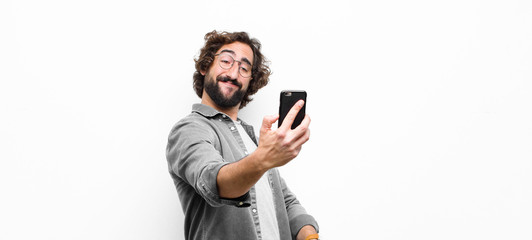 young crazy cool man using his smartphone against white wall