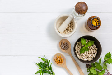 Herbal supplement in capsules with healthy medicinal plant.Alternative drug or natural pharmaceutical capsule.Medication of vitamin supplemental for care and treatment.Top view.
