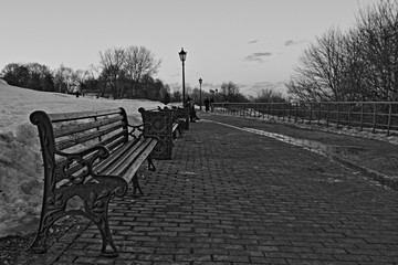 Empty benches and stone paving pathway in Kolomenskoye Park, Moscow landscape view on a winter evening