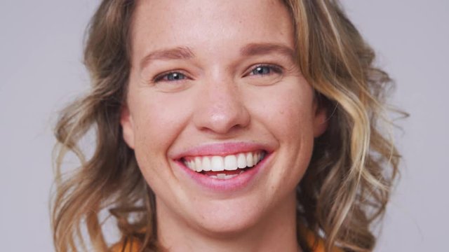 Close Up Head And Shoulders Studio Shot Of Woman Laughing At Camera In Slow Motion