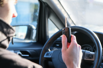 Driving school, a young driver driving a car. Ignition key in hand.