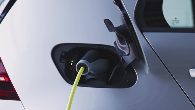 Close Up Of Power Cable Charging Environmentally Friendly Zero Emission Electric Car In Garage 