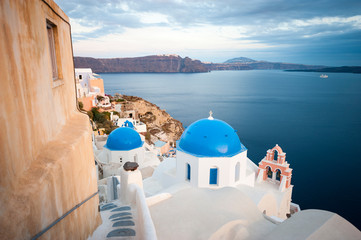 Scenic view of blue church domes dominating the frame in the Mediterranean hillside village of Oia in Santorini, Greece