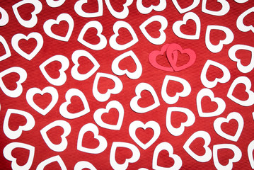 A pair of red hearts coupled up in a frame full of silver hearts on a textured background