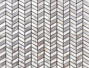 Tiles of pieces of marble and metal are laid out in the shape of a herringbone.