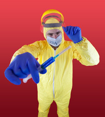 Man in yellow chemical protection suit and face protective mask  with the inscription `coronavirus`. Shoulder portrait. Red background. Without glasses. Protective helmet. Hands in blue gloves. 