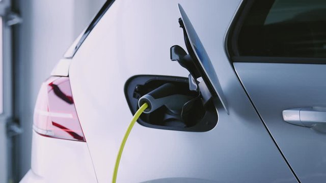 Close Up Of Hand Removing Power Cable From Environmentally Friendly Zero Emission Electric Car 