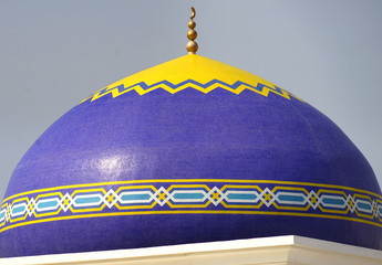 Gelb dekorierte blaue Kuppel einer kleinen Moschee in Maskat