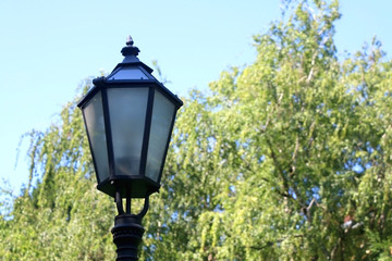 Fototapeta na wymiar Vintage lamp in park in Zagreb, Croatia. Selective focus, green bokeh.